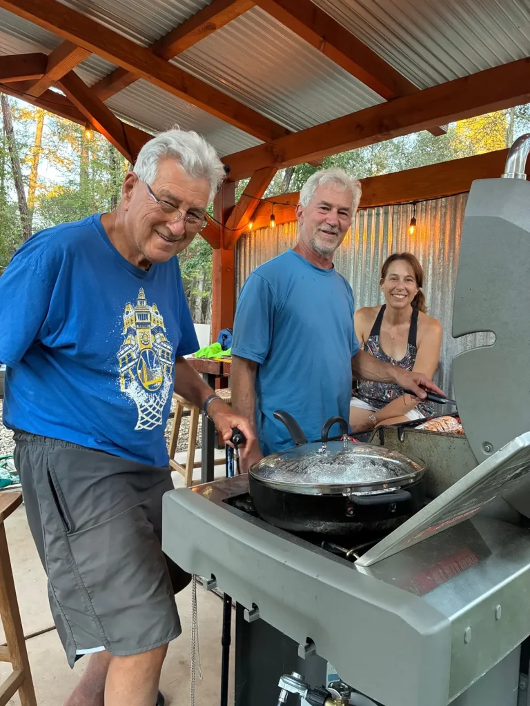 Gib poaching salmon in fig leaves on a grill with friends Mike and Yvonne, the evening before the raft trip